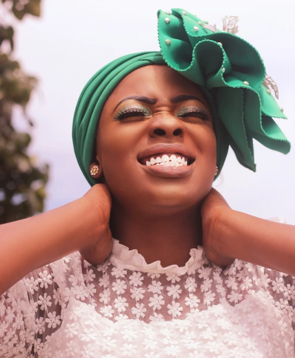 a woman wearing green has a hair bow on her head