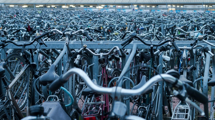 a huge crowd of bicycles parked close together