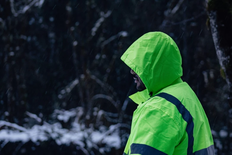 a young man in the snow wearing a bright green jacket