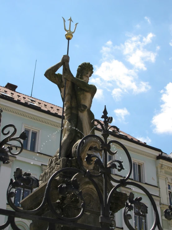 statue of a man with a hammer in his hand on the outside of a building