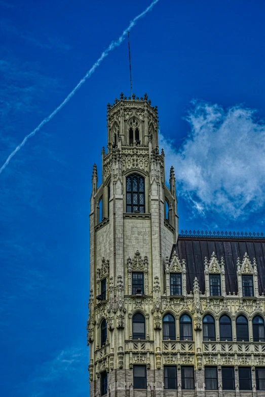 a large old stone building with a steeple under a blue sky