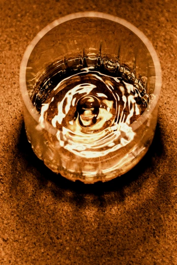 a glass bowl on a table with water reflecting the surface