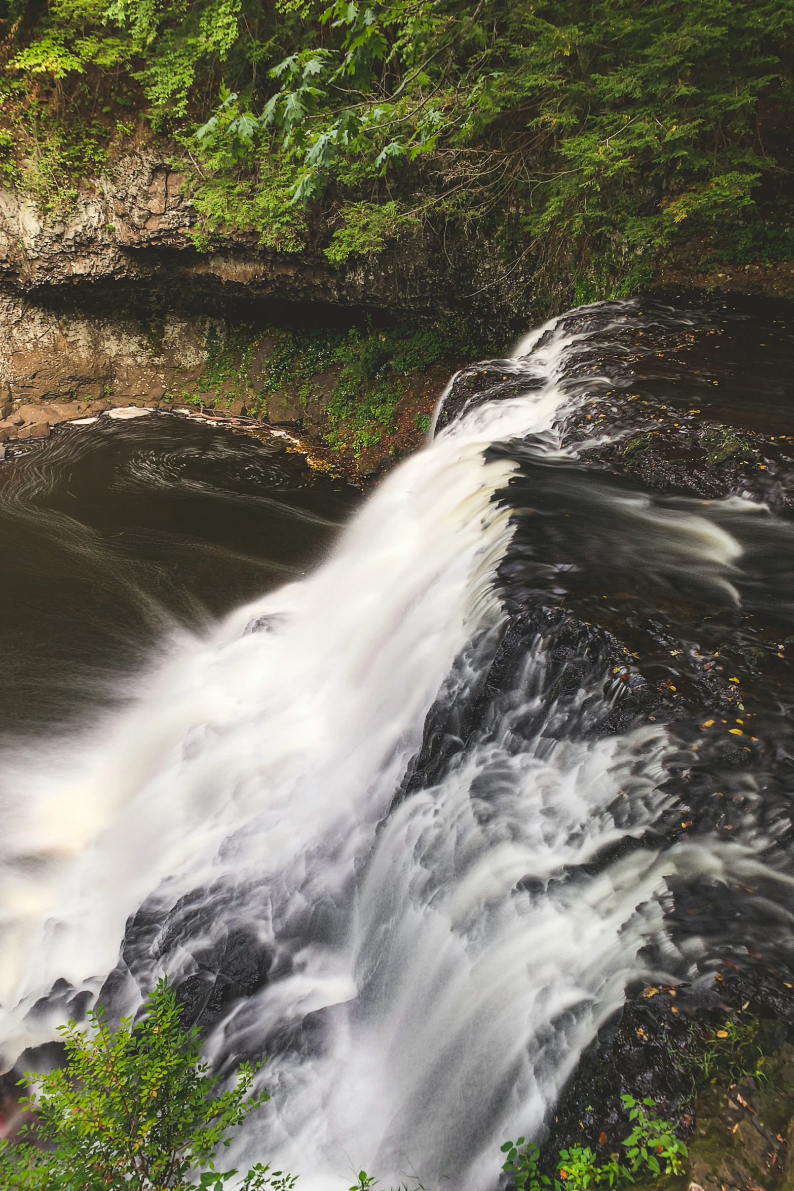 a very large waterfall and some green trees