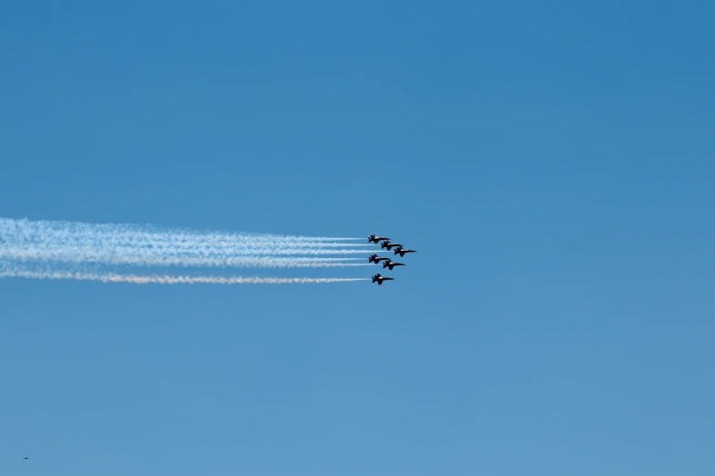 airplanes fly through the sky and leave smoke behind them