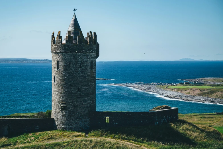 an old castle sitting on top of a hill by the water