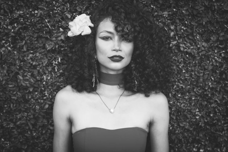 a black and white po of a woman with a rose in her hair