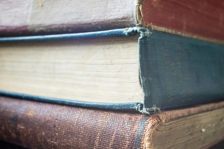 three antique books stacked on top of each other