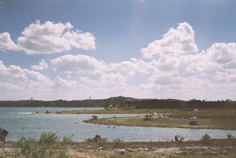 people on horseback near some water and sky