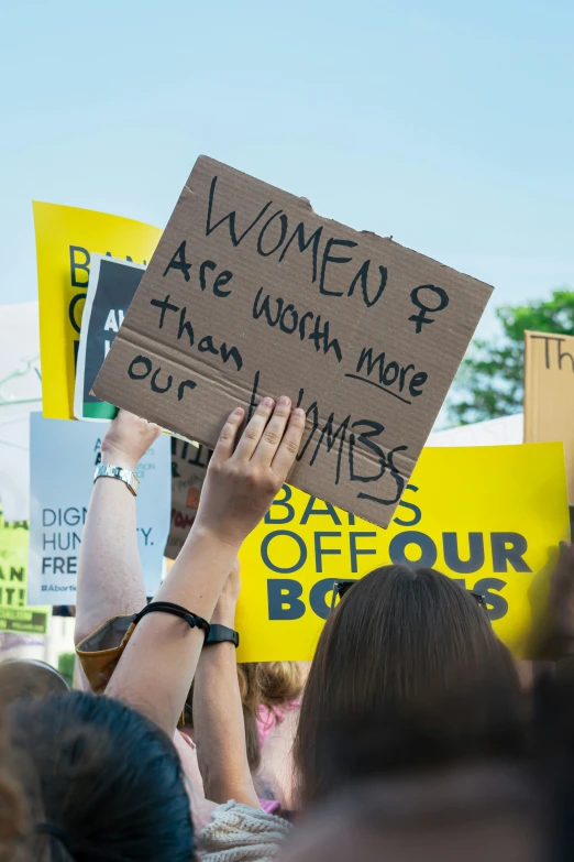 a woman is holding a sign at a protest