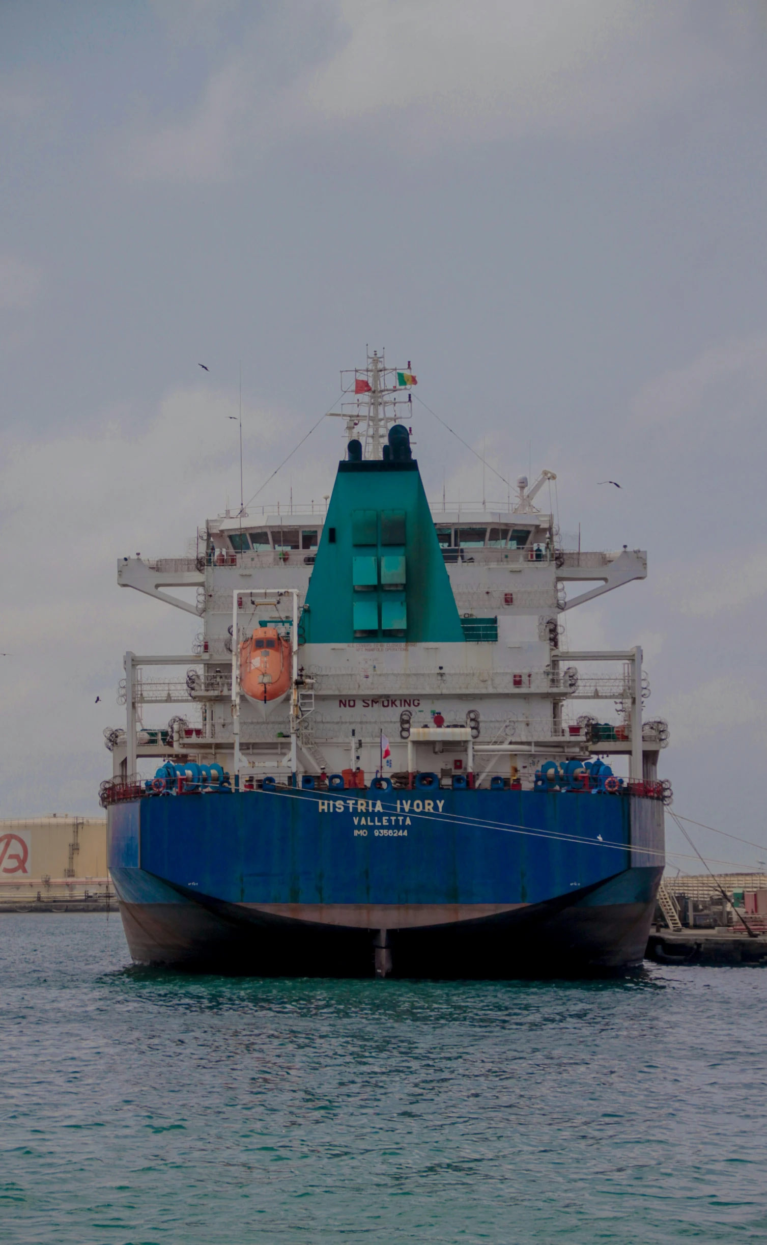 a blue and white ship traveling down a river