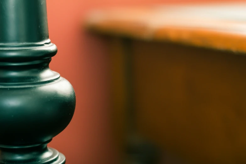 a metal lamp stands on a wood table