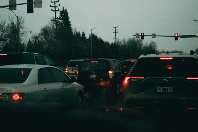 a bunch of cars are waiting at the red traffic light