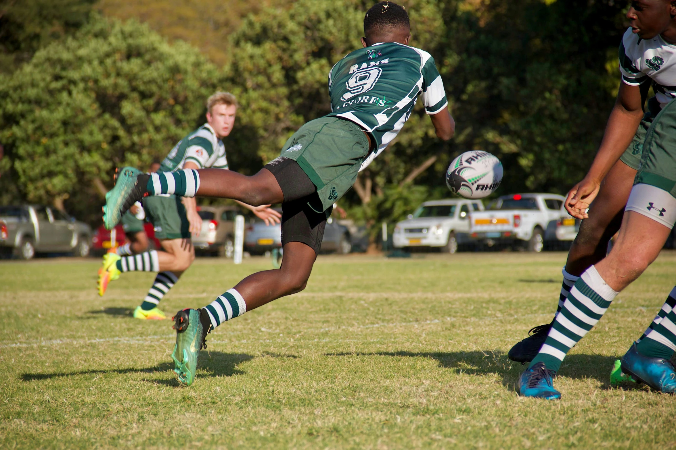 a man kicking a soccer ball across a lush green field