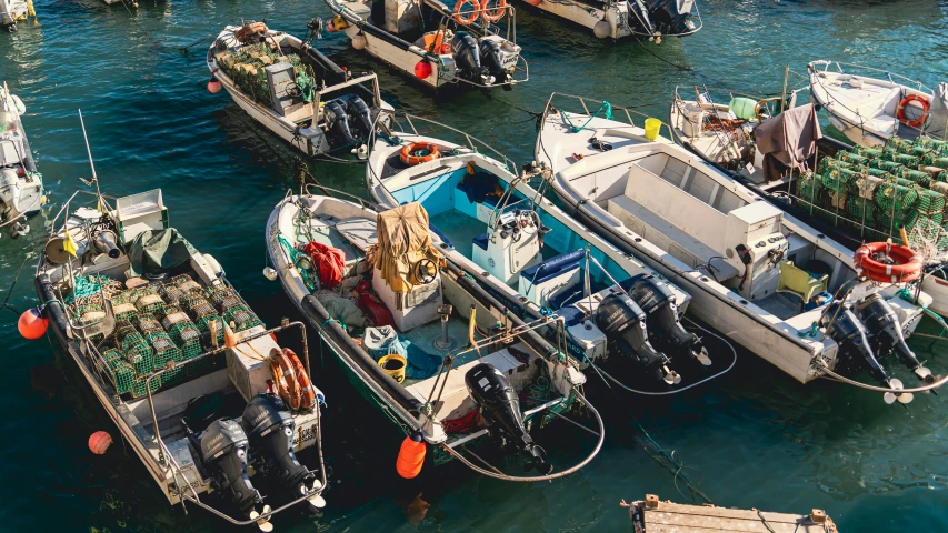 various boats are docked near each other in the water