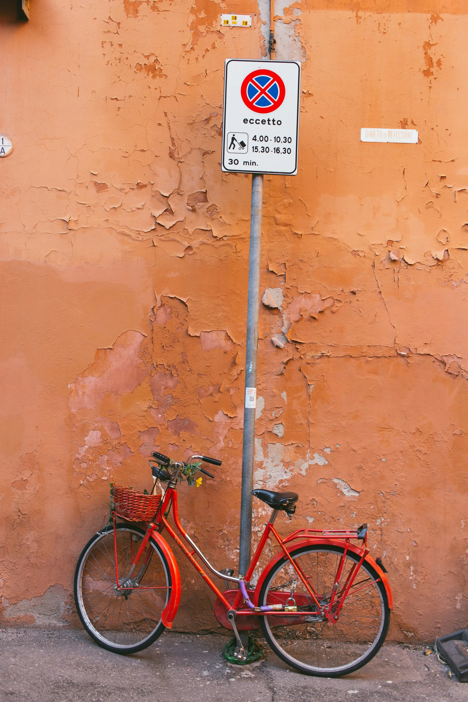 red bicycle parked in front of a red wall