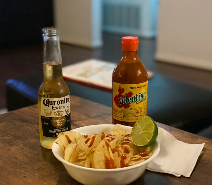 an image of some food in a bowl and bottles of alcohol