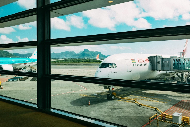 an airport terminal filled with jet airplanes next to the tarmac