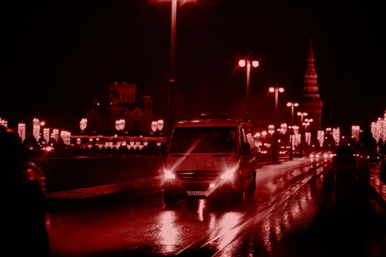 red lights shine down a city street during a rain soaked night