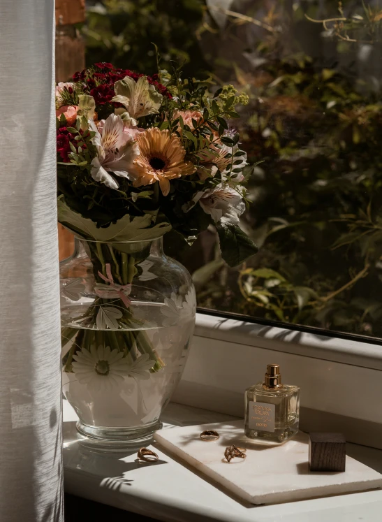 there is a flower arrangement in a vase on the windowsill