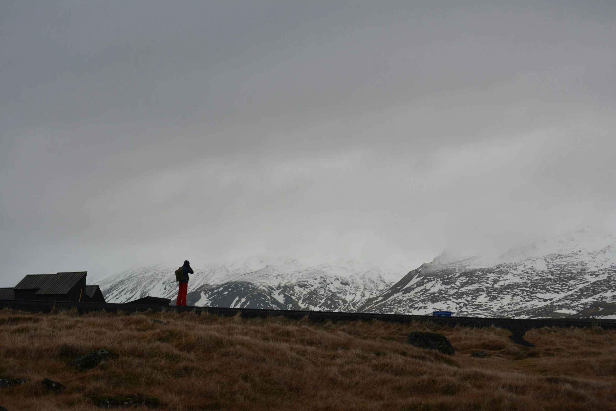 a person is standing on the hill near mountains