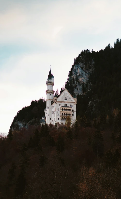 an old castle sits on the side of a hill