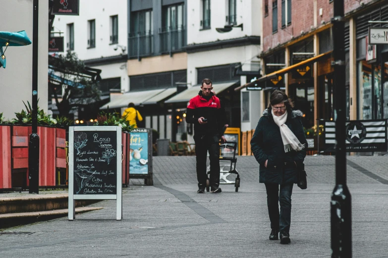 people walk in an open area near the buildings