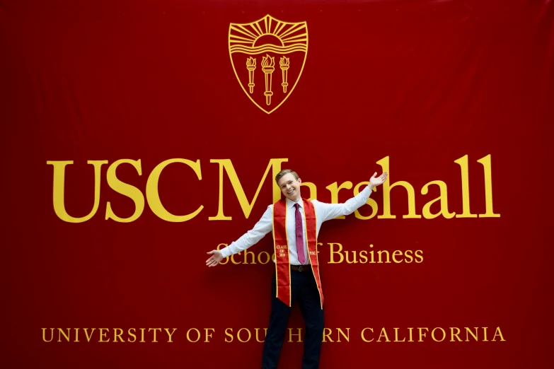 a man is posing for a po in front of a red banner