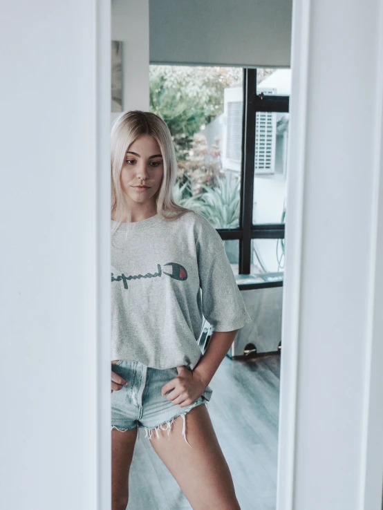 a woman wearing an off - the - shoulder shirt stands in front of a doorway