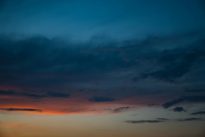 a red cloud over some water with the sky in background