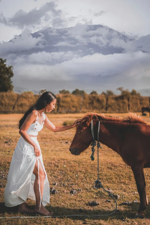 a young woman is walking near a horse