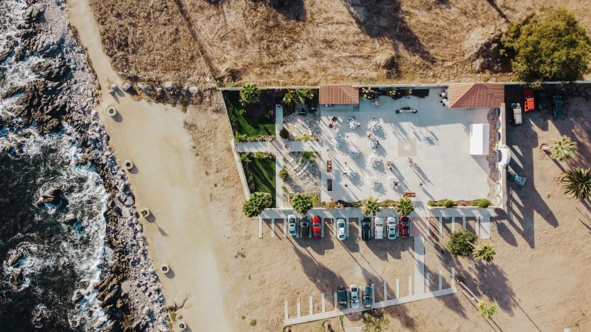 an aerial view of a sandy beach and some blue chairs