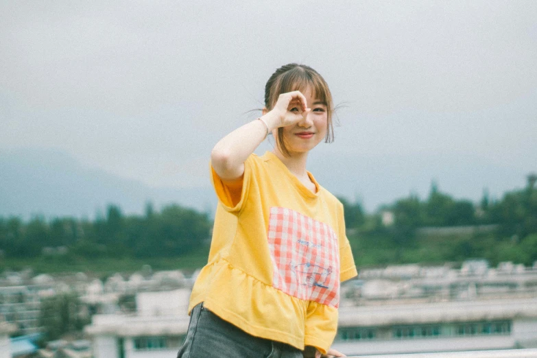 a girl standing near a railing in a yellow shirt