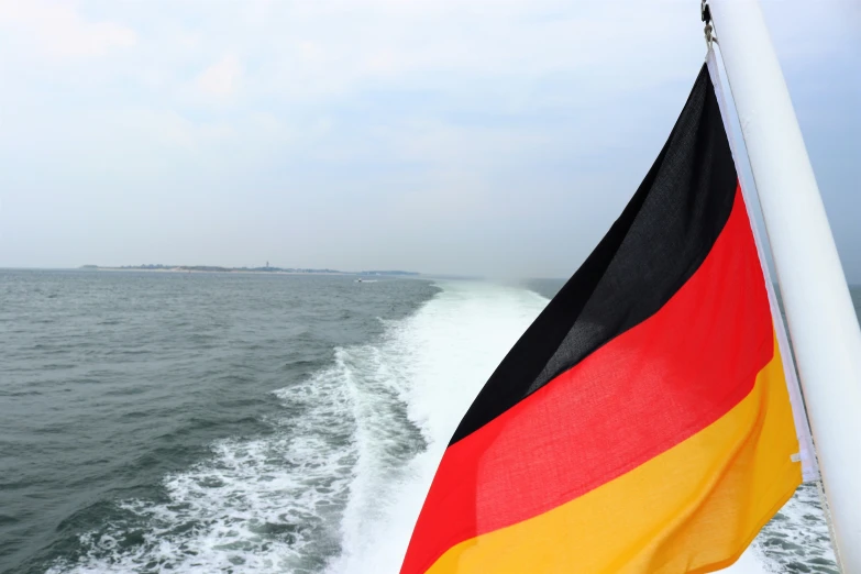 a large flag hangs from the front end of a boat