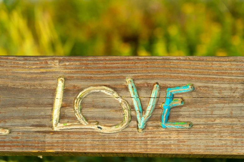 the letters love written with wood on a bench