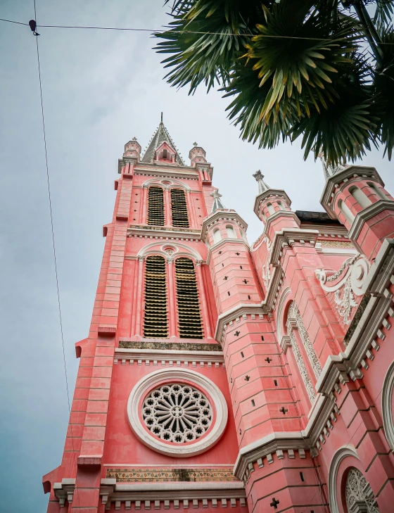 a church is adorned in bright pink stucco and has an ornate clock