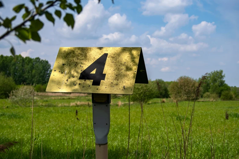 a sign that shows the number four in front of a field