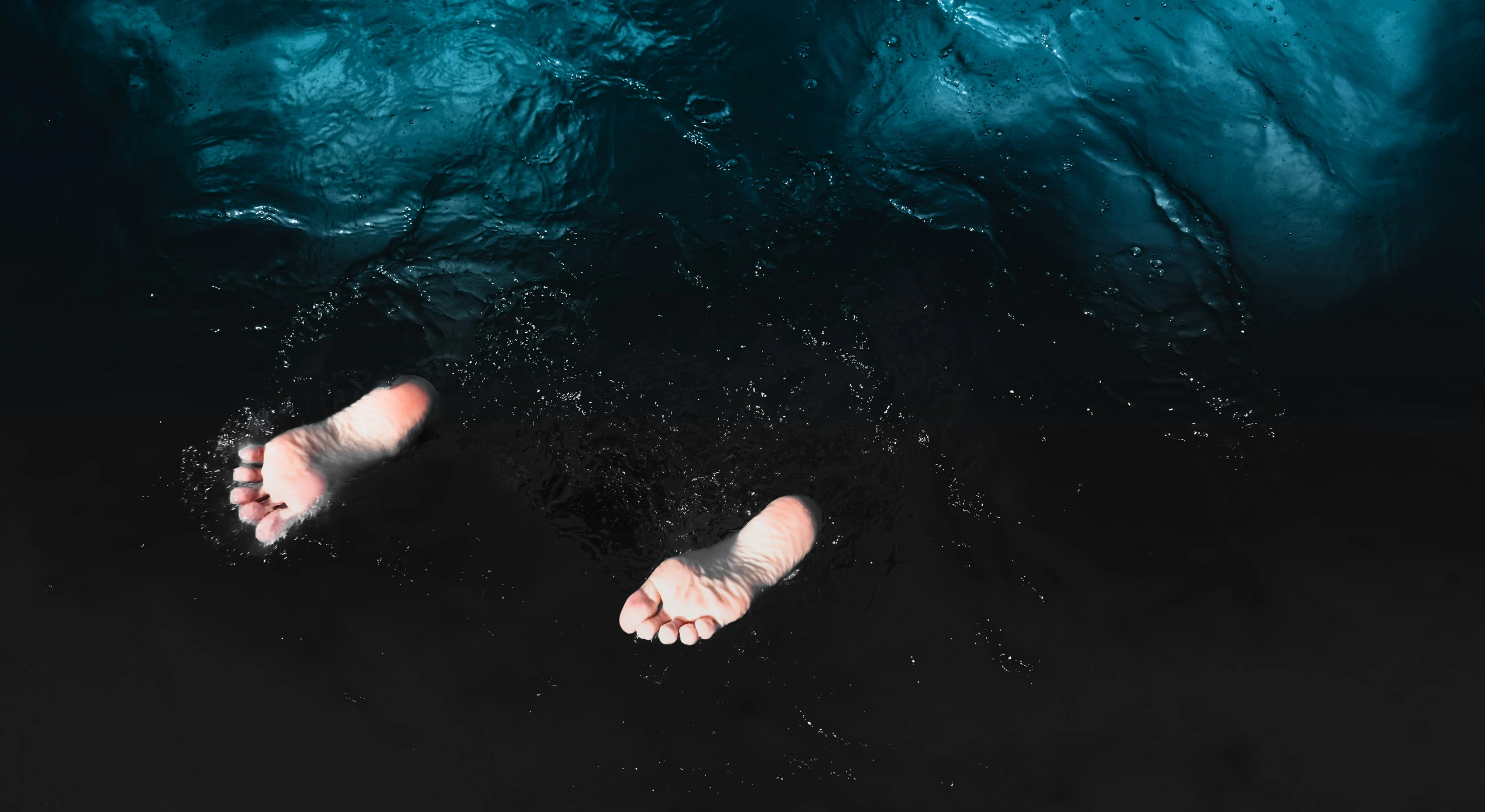 two people feet are seen from above in a body of water