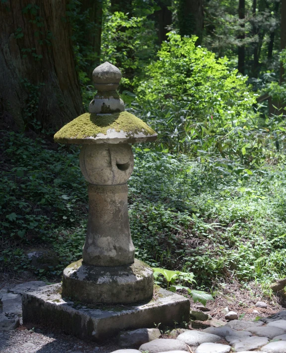 an old stone face statue on the edge of some stairs