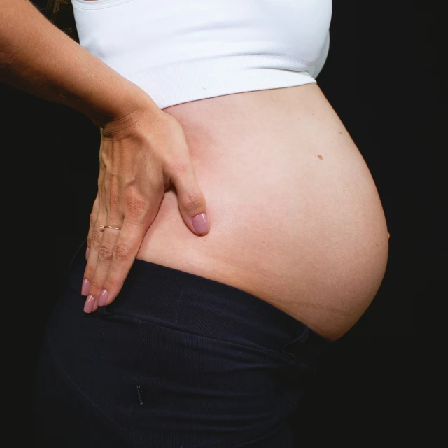 an pregnant woman's belly and her hand on her tummy