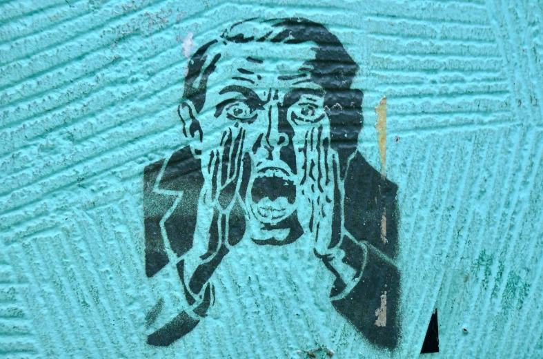 a man with a hand on his face painted on the side of a building