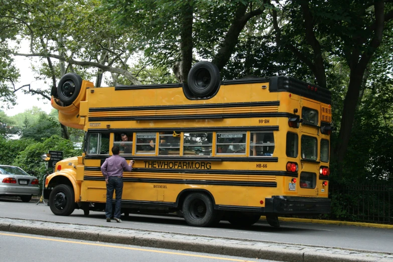 two men standing outside a school bus on the road