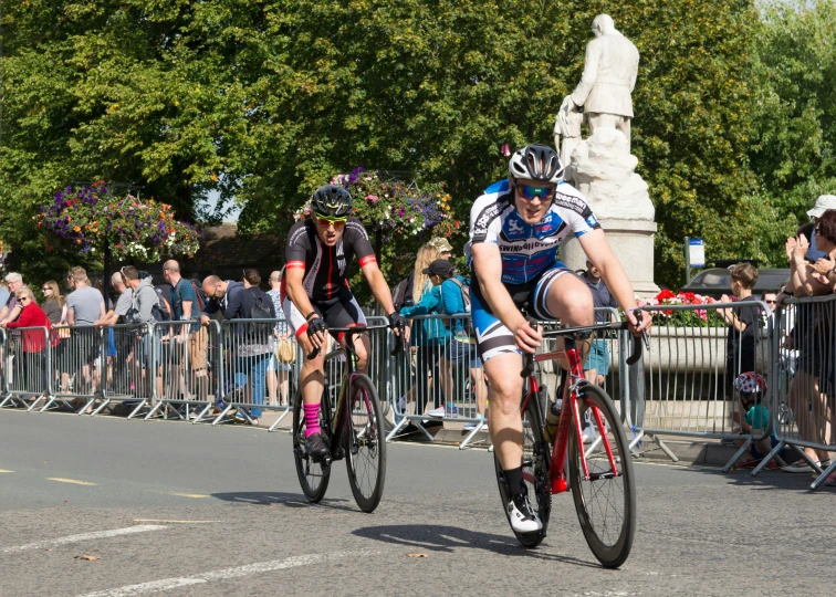 two people riding bikes on a race track