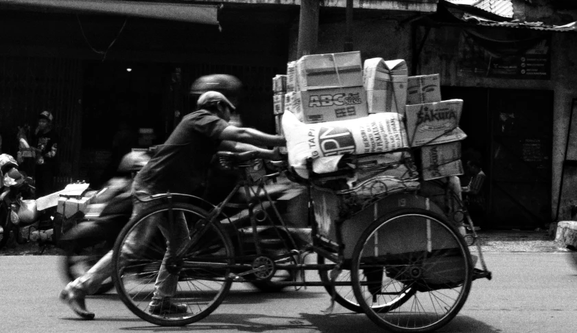 a person on a bike pulling a cart with newspapers