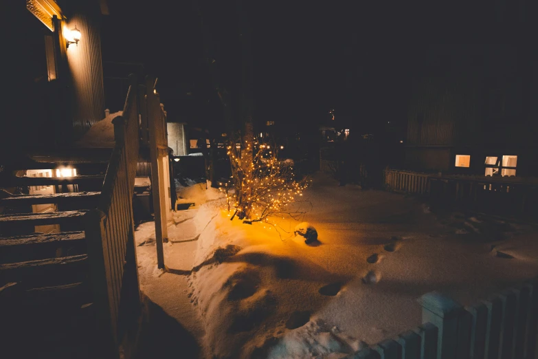 snowy scene of bench lights and street lamp