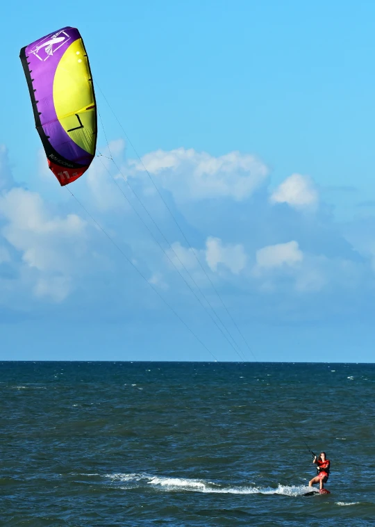 a man on a board water surfing with a para sail