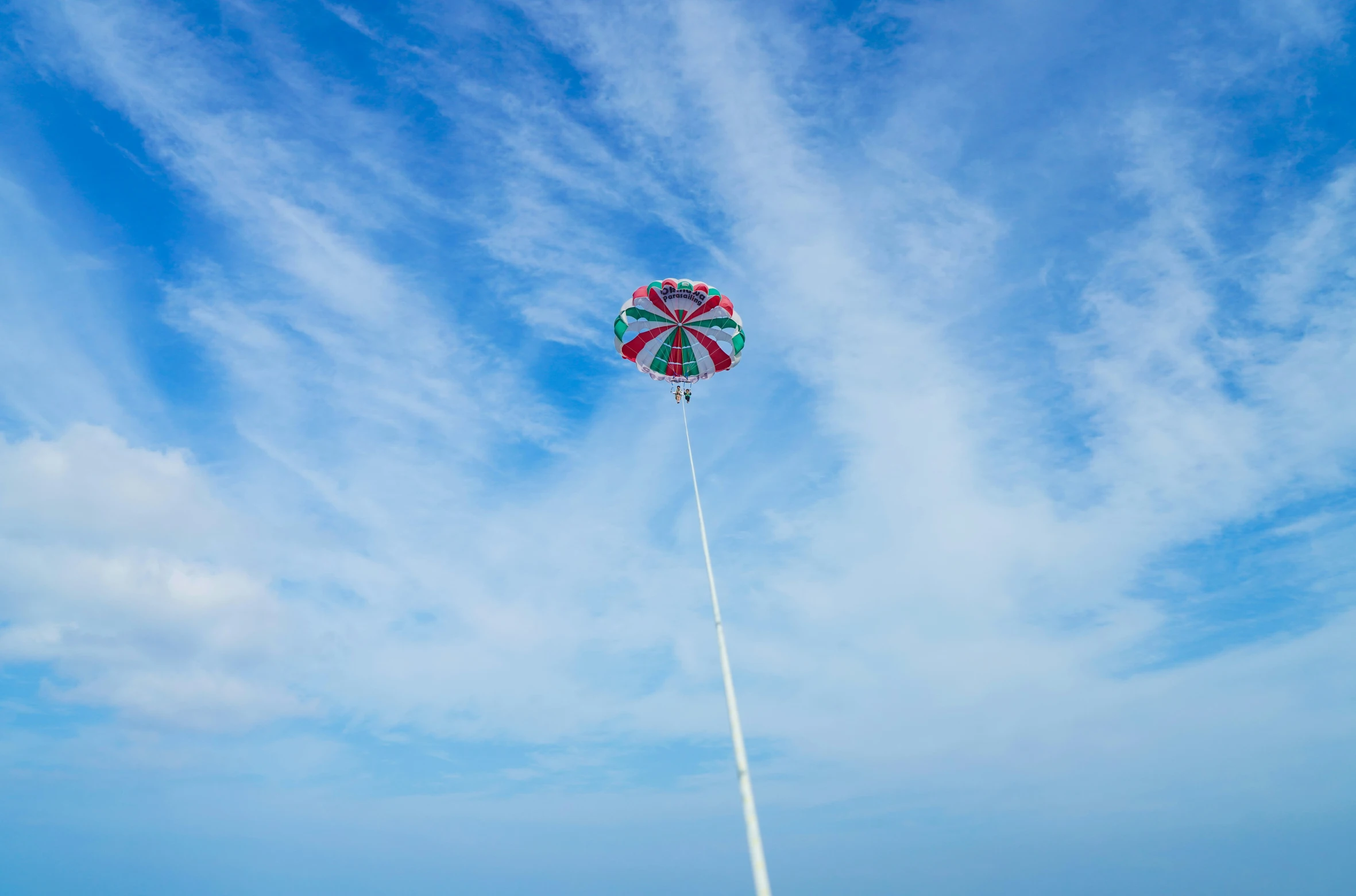 a man flying a kite at the beach on a nice day