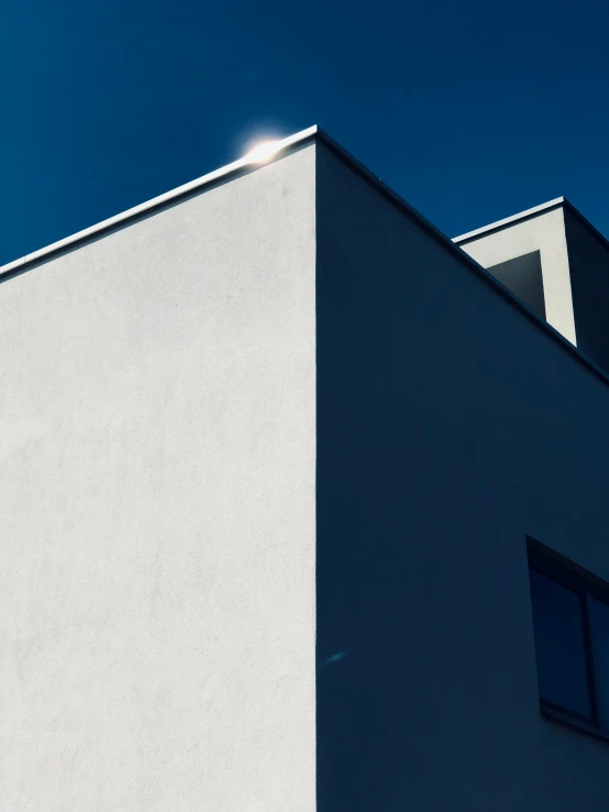 the front corner of a building with the sun shining behind it