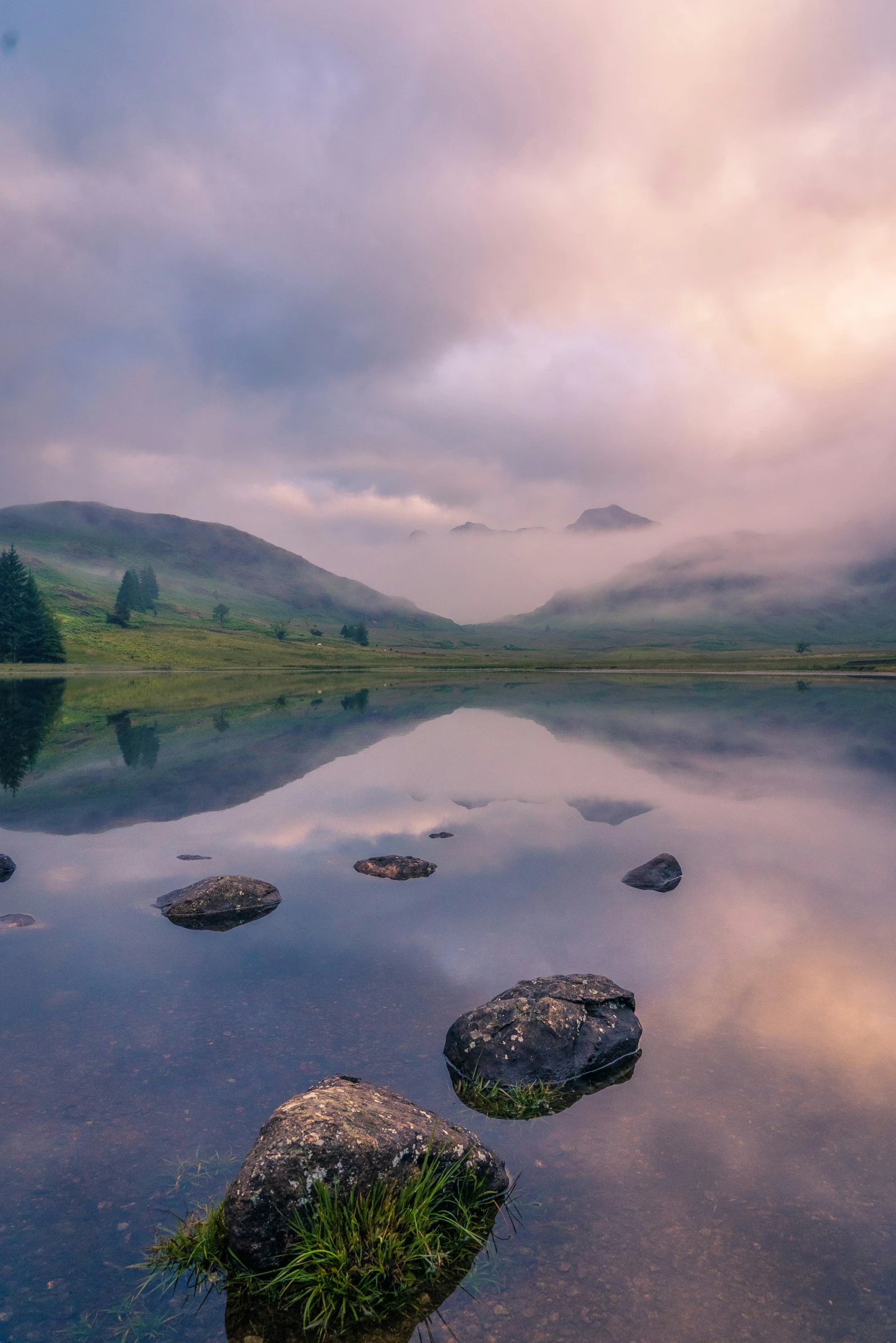 rocks lay in the water on a cloudy day