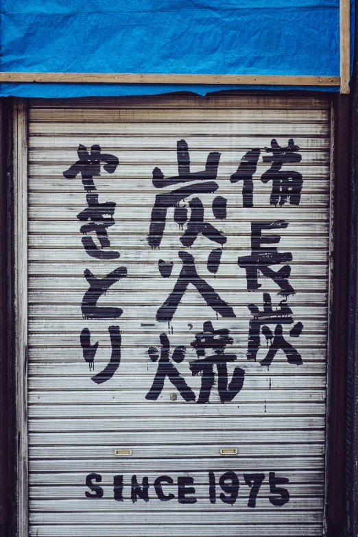 a roller door with graffiti written in chinese on it