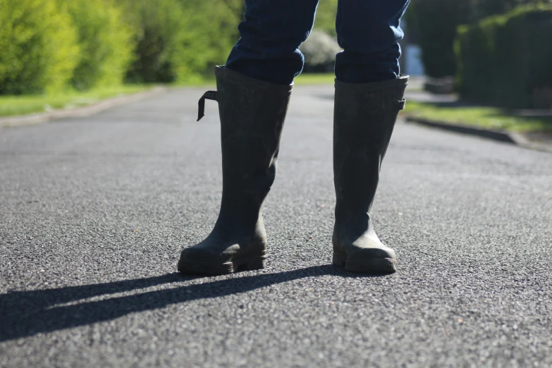 a person in boots standing in the middle of the road